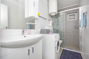 ein weißes Badezimmer mit Waschbecken und Dusche in der Unterkunft Apartment Danica in Makarska + 18 Fotos