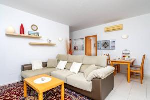 een woonkamer met een bank en een tafel bij Lovely flat with open pool in El Higueron Ref 106 in Benalmádena