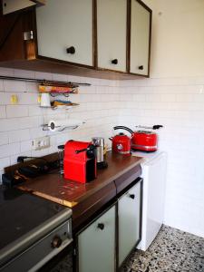 eine Küche mit einer Theke mit roten Geräten in der Unterkunft S'arrulloni in Cagliari