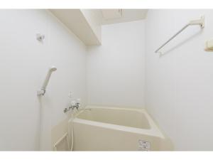 a white bath tub in a white room at Nice Inn Hotel Ichikawa Tokyo Bay in Urayasu