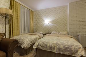 a bedroom with two beds and a chair at Videviku Villa Apartments in Tallinn