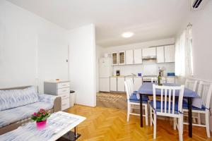ein Wohnzimmer und eine Küche mit einem Tisch und einer Couch in der Unterkunft Apartment Danica in Makarska