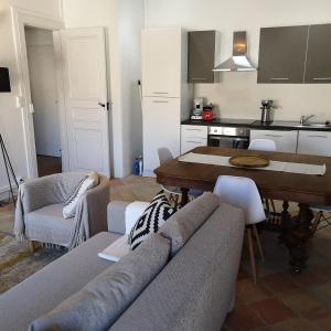 uma cozinha e sala de estar com um sofá e uma mesa em Suite Familiale Saint-Exupéry-Spacieux-Hypercentre-wifi-vélo em Castelnaudary