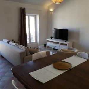 uma sala de estar com uma mesa e uma televisão em Suite Familiale Saint-Exupéry-Spacieux-Hypercentre-wifi-vélo em Castelnaudary