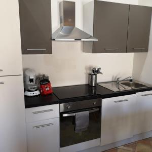 uma cozinha com armários brancos e um lavatório em Suite Familiale Saint-Exupéry-Spacieux-Hypercentre-wifi-vélo em Castelnaudary