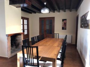 ein Esszimmer mit einem Holztisch und Stühlen in der Unterkunft Casa Rural Fuente la Bolera in Gilbuena