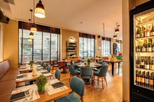 - un restaurant avec des tables, des chaises et des bouteilles de vin dans l'établissement Prassede Palace Hotel, à Rome