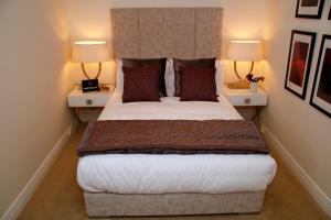a bedroom with a large bed with two lamps at Portfolio Apartments - Welwyn Business Park in Welwyn Garden City