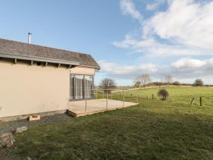a house with a wooden deck next to a field at Eagle Fern in Bamburgh