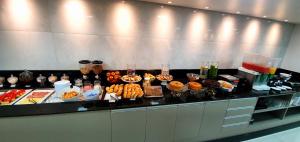 a buffet of food on a counter in a room at Hotel Gemeos in São Mateus