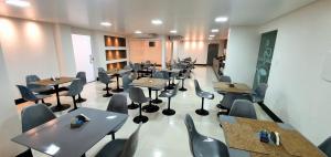 ein Zimmer mit Tischen und Stühlen in einem Restaurant in der Unterkunft Hotel Gemeos in São Mateus