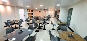 a room with tables and chairs in a restaurant at Hotel Gemeos in São Mateus