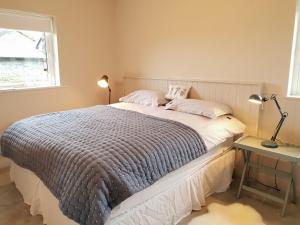 um quarto com uma cama, um candeeiro e uma janela em Murlach Moorings em Ballyconneely
