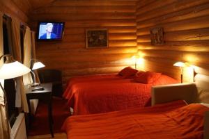 a bedroom with two beds and a television in it at Herrfallet in Arboga