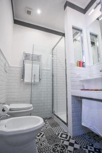 a white bathroom with a toilet and a sink at Relais della Torre in Rome