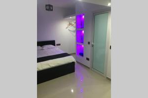 Un dormitorio con una cama con luces moradas. en Studio GARAGE, en Mindelo 5 fotos más