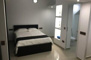 un dormitorio con una cama y un baño en Studio GARAGE, en Mindelo