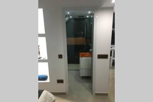 baño con puerta de cristal y lavamanos en Studio GARAGE, en Mindelo