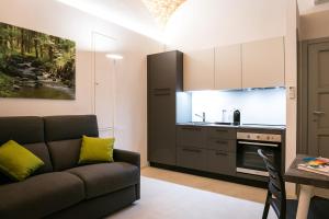 uma sala de estar com um sofá e uma cozinha em Mameli Comfort em Casale Monferrato