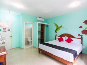 A bed or beds in a room at Hotel Hacienda Bacalar