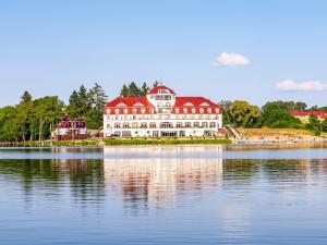 a large building on the shore of a body of water at Hotel Woiński Spa in Lubniewice