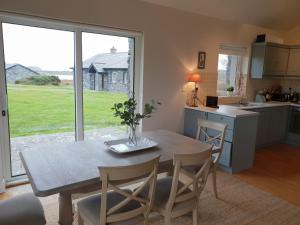 uma cozinha e sala de jantar com mesa e cadeiras em Murlach Moorings em Ballyconneely