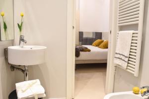 a white bathroom with a sink and a bed at Garibaldi23 Rooms in La Spezia