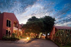 eine Straße mit Gebäuden und Bäumen und einem wolkigen Himmel in der Unterkunft Relais des Plateaux & Spa– Ivato International Airport in Antananarivo