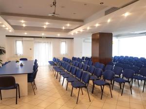a large room with blue chairs and a table in it at Hotel La Dolce Vita in Zărneşti