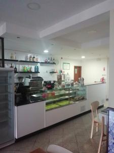 a kitchen with a counter with a glass display at Hospedaria Nunes Pinto in Termas de Sao Pedro do Sul