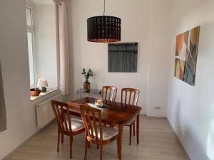 a dining room with a wooden table and chairs at Apartment in a villa with garden in Borstendorf in Wünschendorf