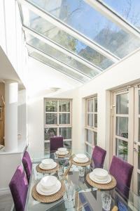 une salle à manger avec une table en verre et des chaises violettes dans l'établissement Georgian Square Apartments, à Dublin