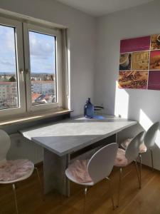 - une cuisine avec une table et deux chaises ainsi que deux fenêtres dans l'établissement Penthouse "Michelangelo" GreatView, WiFi & Netflix, à Schweinfurt