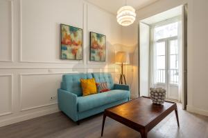 a living room with a blue couch and a coffee table at Morgan-Jupiter Apartments in Lisbon