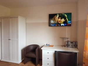 Habitación con escritorio y TV en la pared. en Flensburg Ferienwohnungen Apartment 1, en Flensburg