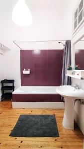 a bathroom with a bath tub and a sink at Espinho Guesthouse - Garden House in Espinho