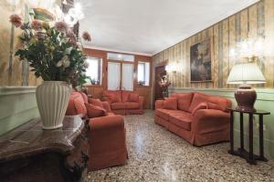 a living room with orange furniture and a vase of flowers at Palazzo Cendon Piano Antico in Venice