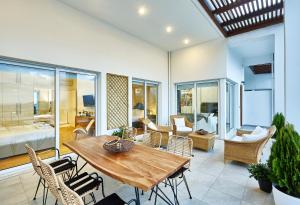 sala de estar con mesa de madera y sillas en Spacious Mint Luxury Villa access to Private Beach en Agia Pelagia