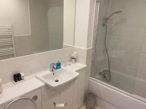 a white bathroom with a sink and a shower at 23 Hedgefield House in Inverness