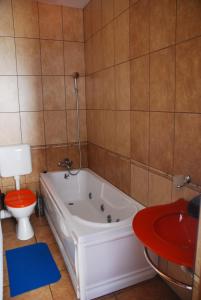 a bathroom with a white tub and a toilet at Pension La Noblesse in Bucharest