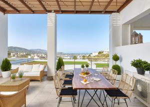 a patio with a table and chairs on a balcony at Spacious Mint Luxury Villa access to Private Beach in Agia Pelagia