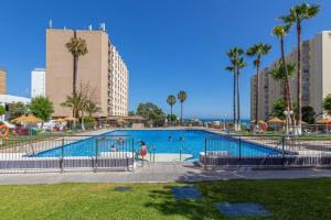 een zwembad in een resort met palmbomen bij 797 Holiday Rentals - Amplio estudio en Puerto Marina in Benalmádena