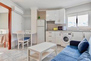 een woonkamer met een bank en een tafel en een keuken bij 797 Holiday Rentals - Amplio estudio en Puerto Marina in Benalmádena