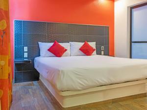 a bedroom with a large white bed with red pillows at Hotel SR92 Adults Only in Mexico City