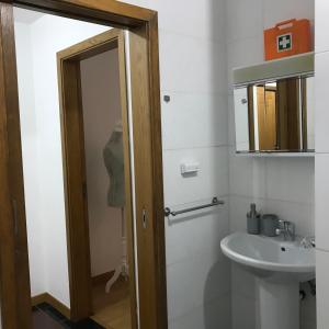 a bathroom with a sink and a toilet and a mirror at Miguel Torga Apartments in Coimbra