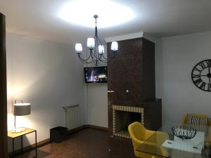 a living room with a fireplace and a chandelier at Miguel Torga Apartments in Coimbra