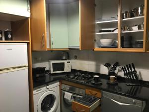 a small kitchen with a stove and a microwave at Miguel Torga Apartments in Coimbra