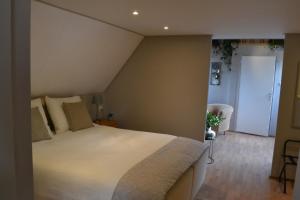 um quarto com uma grande cama branca num quarto em B&BBolwerk em Venray