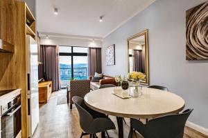a dining room and living room with a table and chairs at Menlyn Maine Residence Unit 1419 in Pretoria