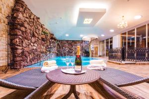 um quarto com uma piscina e uma mesa com uma garrafa de vinho em Parkhotel Brno em Brno